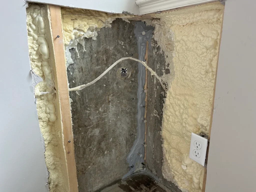 Foundation wall crack repair in Amesbury MA showing exposed basement wall and sealed crack repair system.