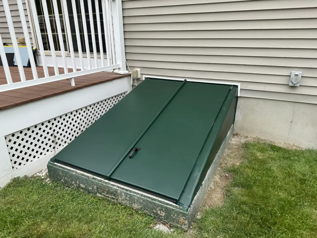 New green steel bulkhead door installed on a home in Methuen, MA replacing a deteriorated basement entrance door.