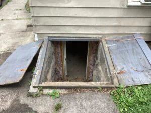 Old damaged wooden bulkhead door before replacement at a home in Nashua, NH.