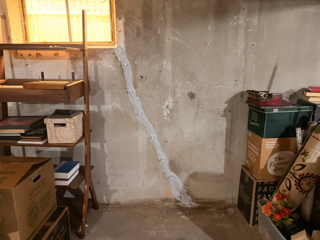 Before and after foundation wall crack repair in a Salem, MA basement, showing a professionally sealed diagonal concrete wall crack to prevent future water intrusion.