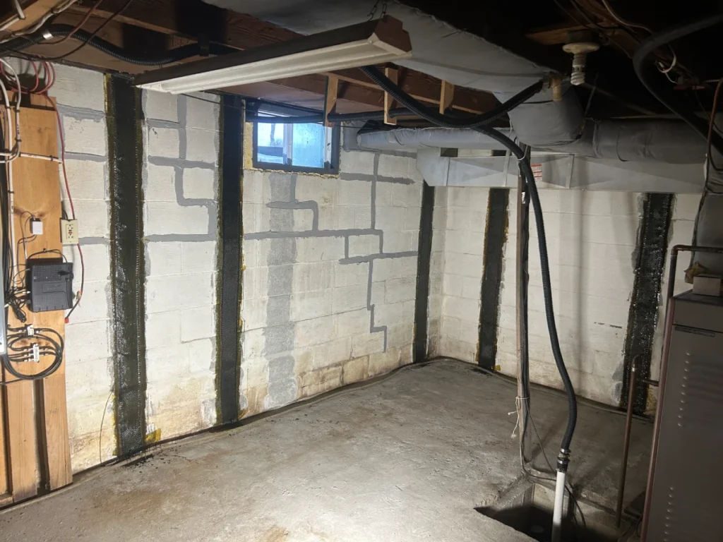 Basement foundation walls with repaired cracks and vertical reinforcement for structural support