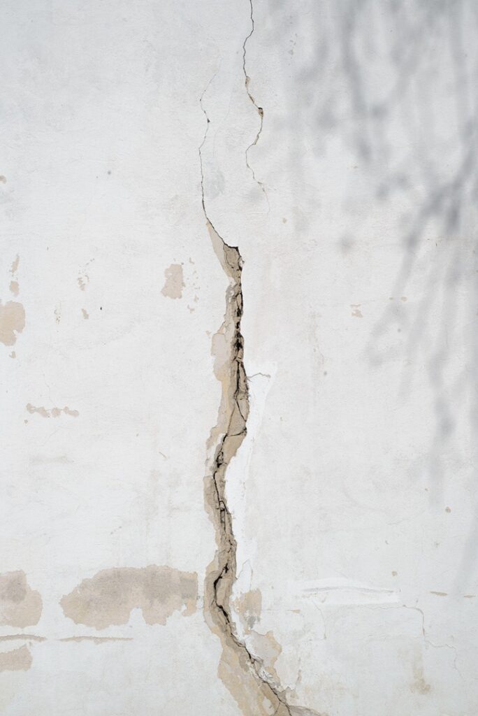 Vertical foundation wall crack showing damaged concrete before foundation crack repair in New England
