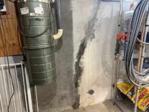 Previously patched displaced foundation wall crack in Manchester, NH, before structural repair