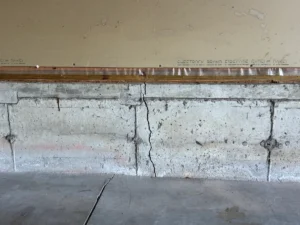 Wide vertical crack in a concrete foundation wall before repair in Saco, ME