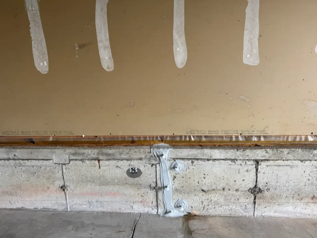 Repaired foundation wall crack with epoxy application points in Saco, ME