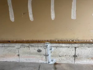 Repaired foundation wall crack with epoxy application points in Saco, ME