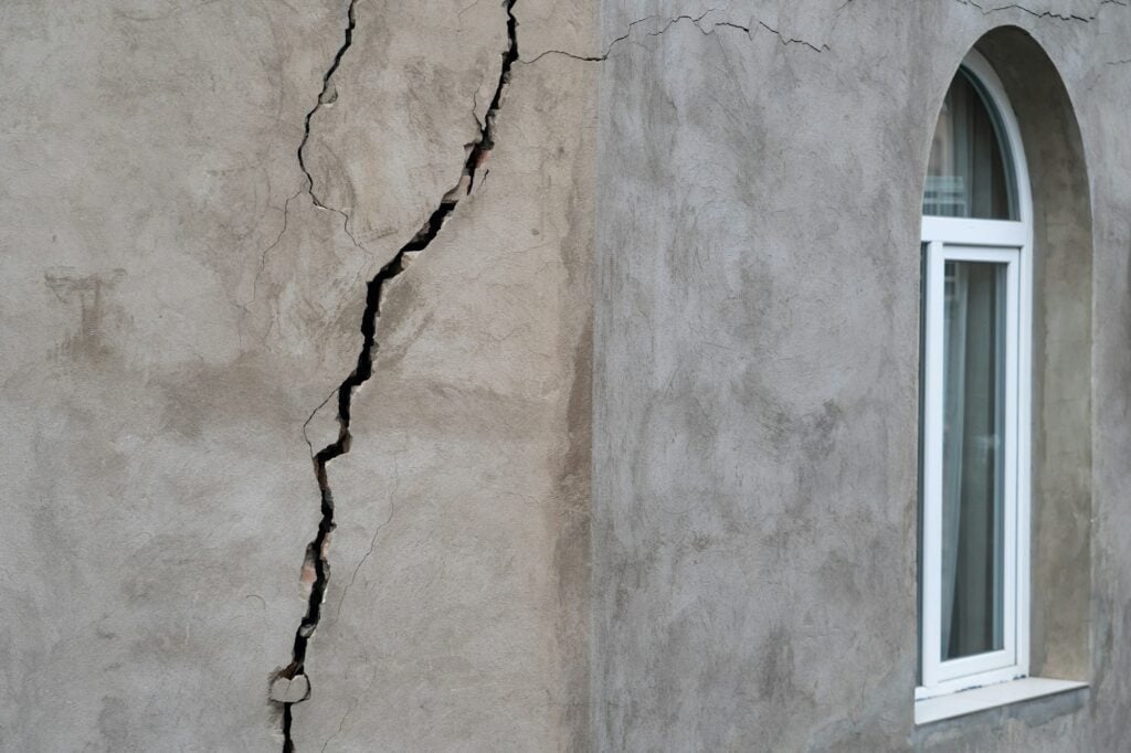 Large vertical foundation crack running through the exterior wall of a home